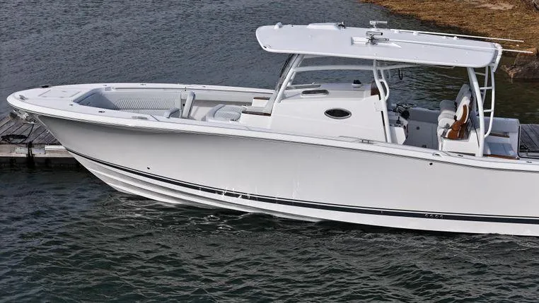 Slide: The Image of 2025 Southport 38 FE boat on water, sleek design, white exterior, docked. - 5