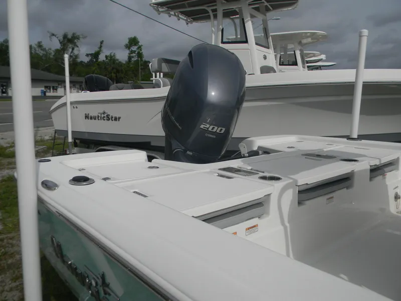 Slide: The Image of 2023 NauticStar 227 XTS boat with Yamaha 200 engine, docked outdoors. - 6