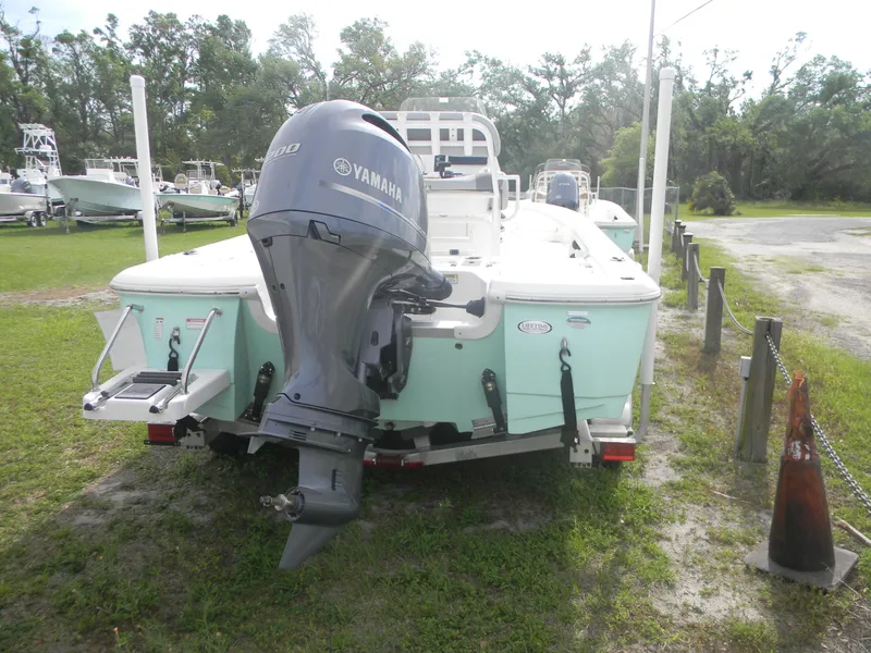 Slide: The Image of 2023 NauticStar 227 XTS boat with Yamaha outboard motor, parked on grass. - 7