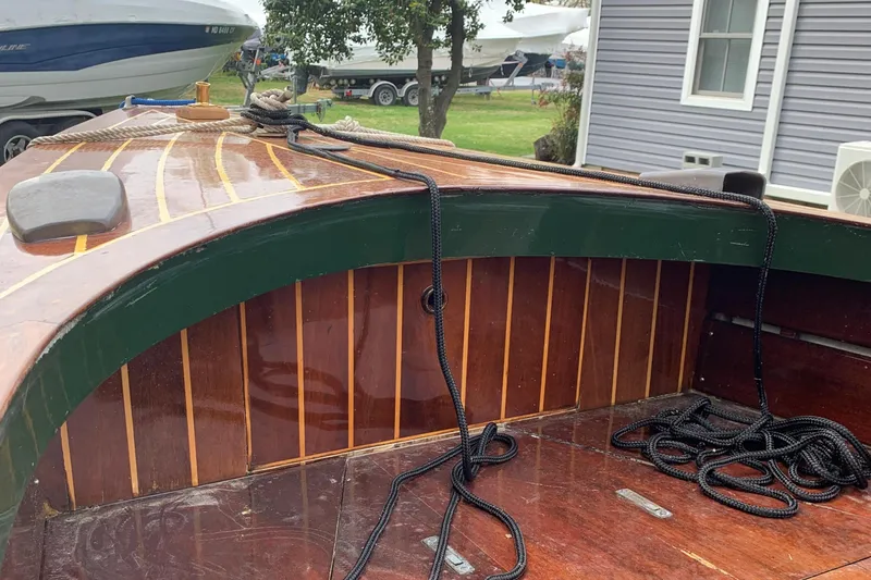 Slide: The Image of Classic 1990 English Launch boat with wooden deck and ropes, docked near other boats. - 33