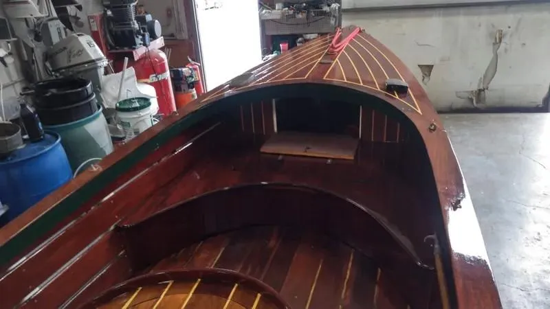 Slide: The Image of Classic 1990 English Launch boat with polished wooden interior in a workshop setting. - 4