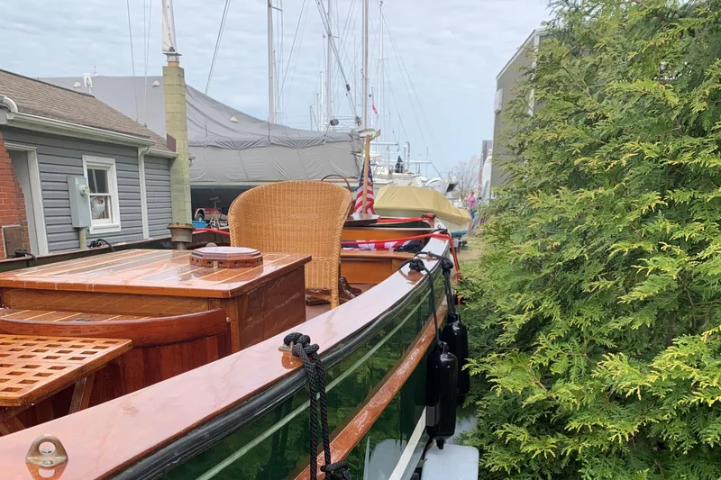 Slide: The Image of Classic English Launch boat from 1990 docked near greenery and buildings. - 40