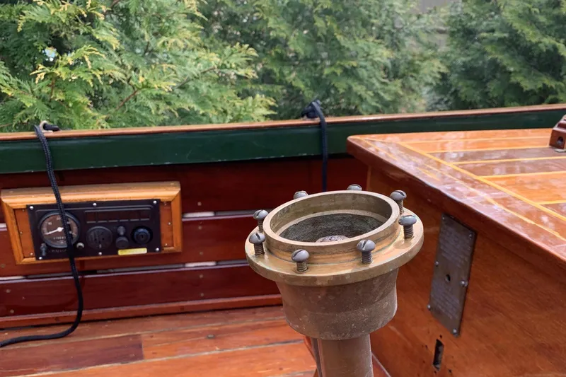 Slide: The Image of Classic English Launch boat interior with vintage brass fittings and wooden paneling, surrounded by lush greenery. - 46