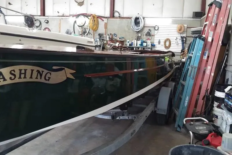 Slide: The Image of Classic English Launch boat from 1990 in a workshop, surrounded by tools and equipment. - 5