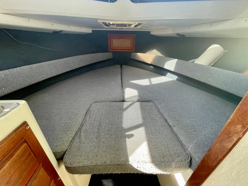 Slide: The Image of Interior cabin of a 1993 Skipjack 263 Fisherman boat with gray upholstery. - 12