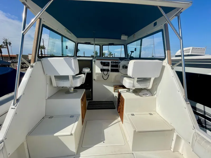 Slide: The Image of Interior view of a 1993 Skipjack 263 Fisherman boat with seating and controls. - 21