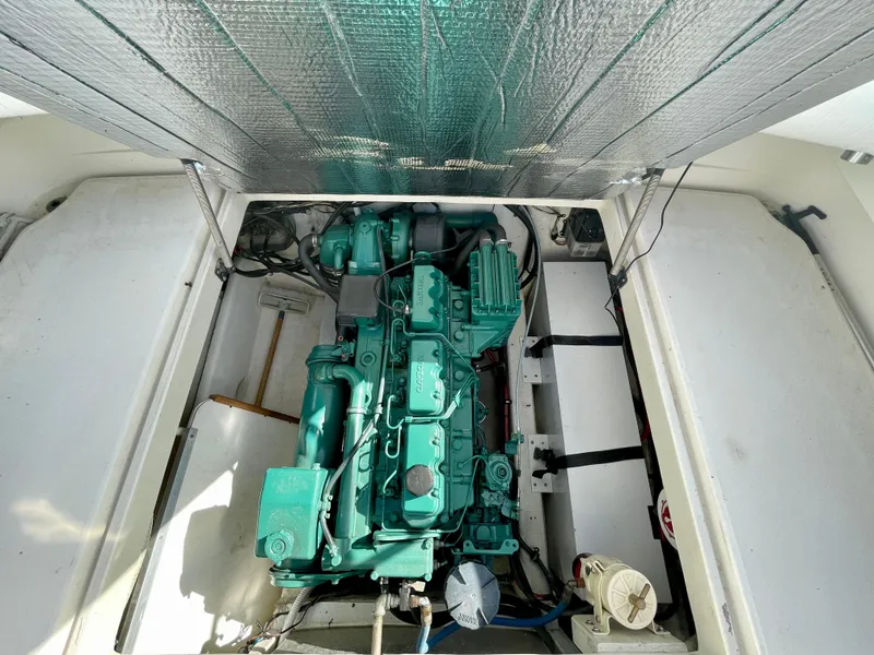 Slide: The Image of Engine compartment of a 1993 Skipjack 263 Fisherman boat, showcasing a green marine engine. - 25