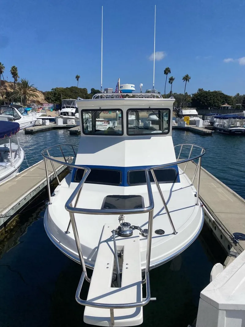 Slide: The Image of 1993 Skipjack 263 Fisherman boat docked in a marina under clear blue skies. - 4