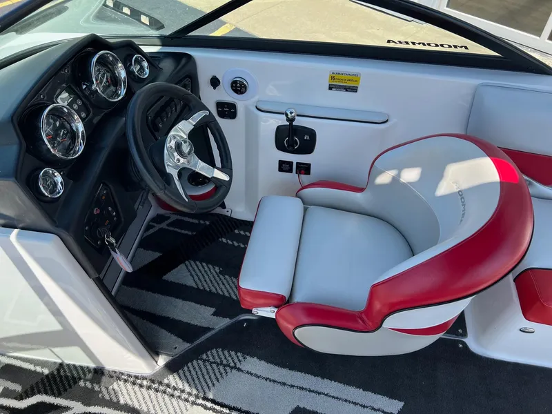 Slide: The Image of 2013 Moomba Mojo 2.5 boat interior with red and white captain's chair and dashboard controls. - 13