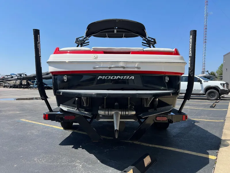 Slide: The Image of 2013 Moomba Mojo 2.5 boat, rear view, parked in a lot under clear blue sky. - 5
