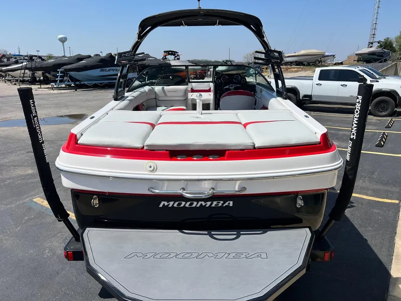 Slide: The Image of 2013 Moomba Mojo 2.5 boat with red and white seating, parked in a marina. - 6