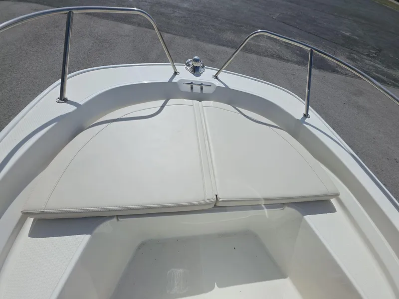 Slide: The Image of 2024 Boston Whaler 150 Montauk boat bow with cushioned seating and stainless steel railings. - 11