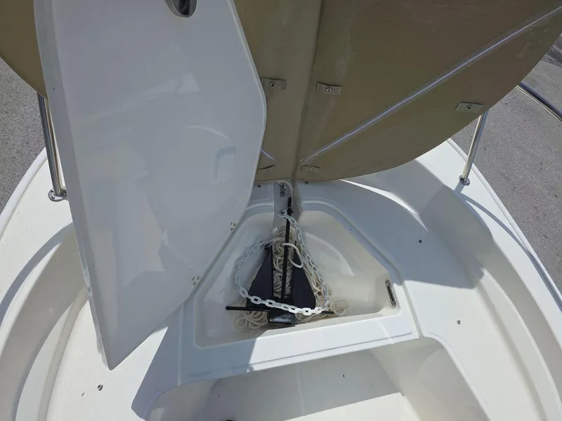 Slide: The Image of 2024 Boston Whaler 150 Montauk anchor storage compartment with open hatch. - 12
