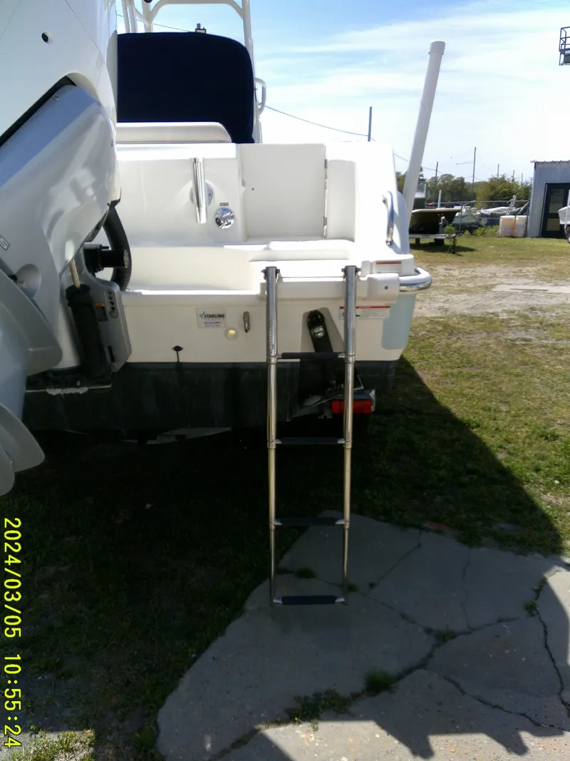 Slide: The Image of 2021 Boston Whaler Outrage 230 with ladder, parked on grass. - 12