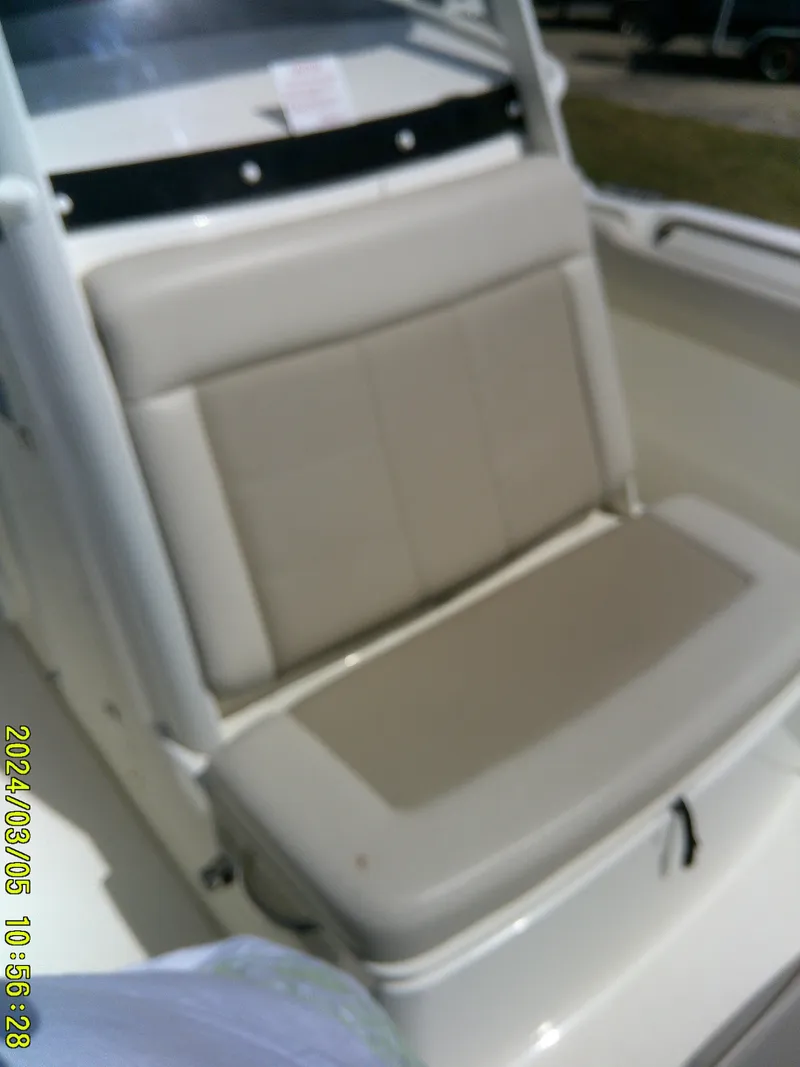 Slide: The Image of 2021 Boston Whaler Outrage 230 boat seat, beige upholstery, outdoor setting. - 16