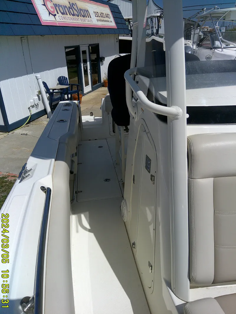 Slide: The Image of 2021 Boston Whaler Outrage 230 boat, side view, docked near a building. - 17