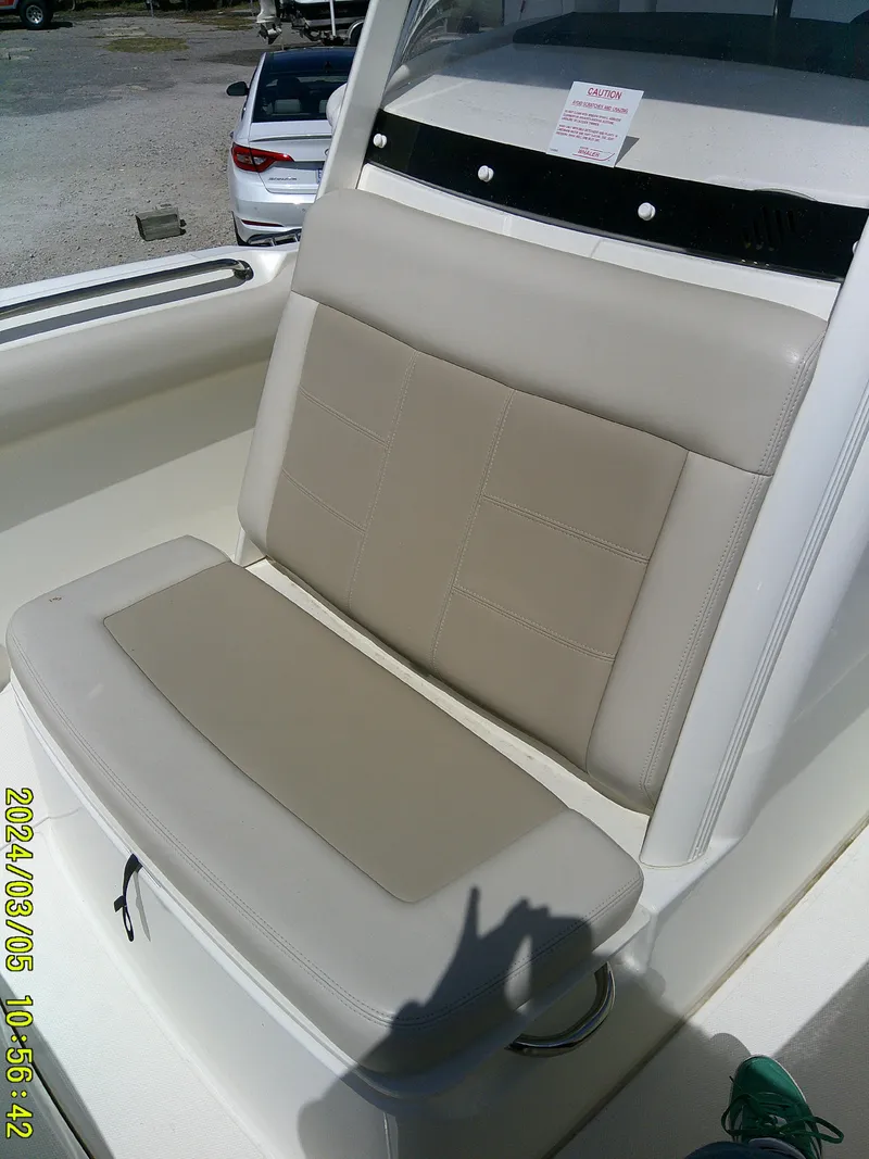 Slide: The Image of 2021 Boston Whaler Outrage 230 boat seat, beige upholstery, outdoor setting. - 19
