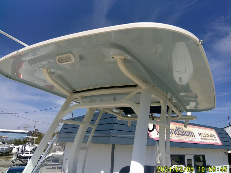 Slide: The Image of Boston Whaler Outrage 230 (2021) T-top structure under clear blue sky. - 20