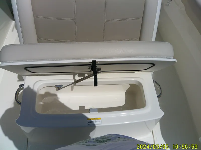 Slide: The Image of Boston Whaler Outrage 230 (2021) seat storage compartment open, showcasing interior space. - 21