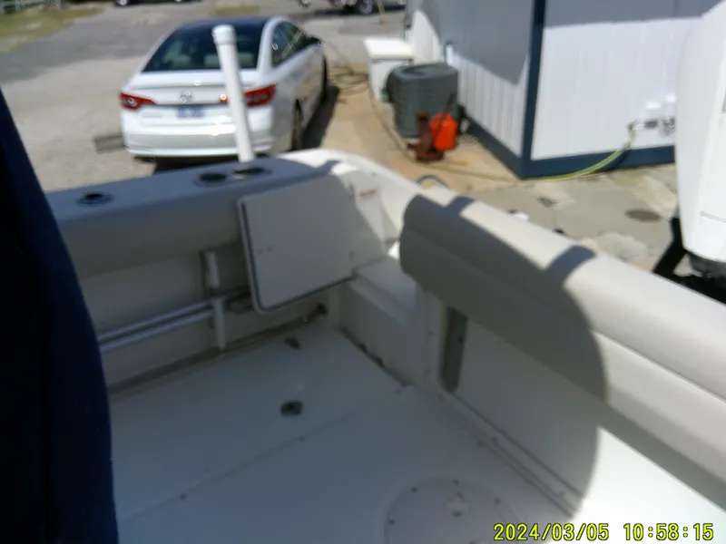 Slide: The Image of 2021 Boston Whaler Outrage 230 boat interior with seating and docked car nearby. - 30