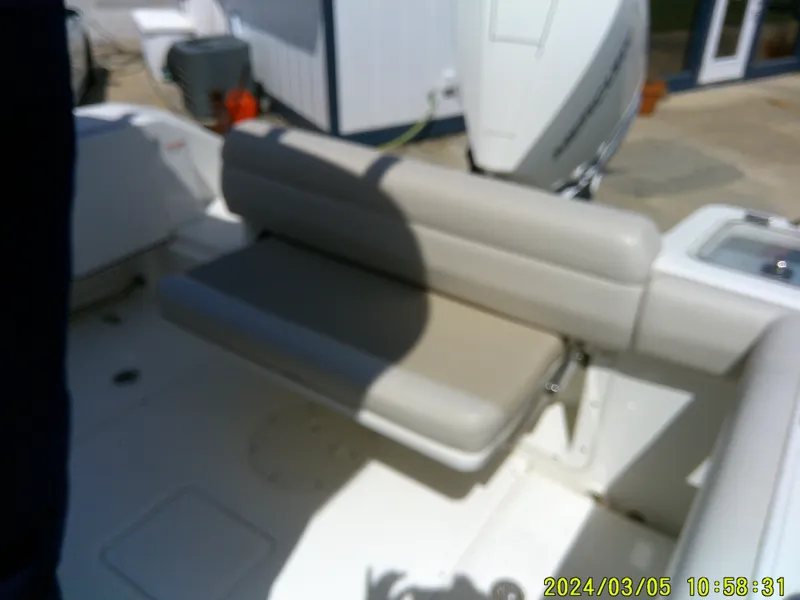 Slide: The Image of 2021 Boston Whaler Outrage 230 boat interior with beige seating and outboard motor. - 32