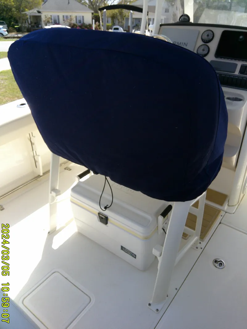 Slide: The Image of 2021 Boston Whaler Outrage 230 boat seat with blue cover and cooler underneath. - 37