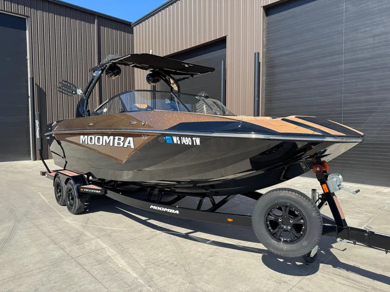 Slide: The Image of 2022 Moomba Makai boat on trailer, parked outside industrial building. - 1