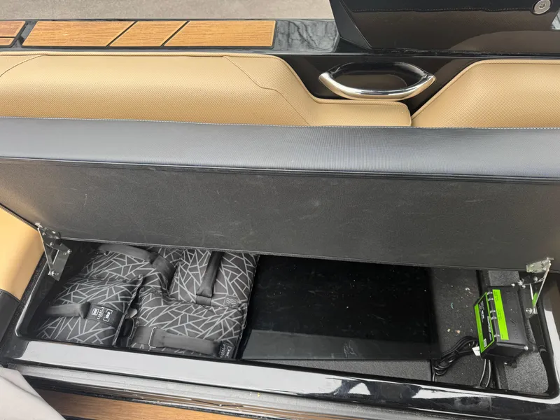 Slide: The Image of 2022 Moomba Makai boat interior storage compartment with life jackets and electronic device. - 10