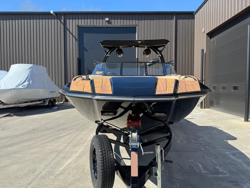 Slide: The Image of 2022 Moomba Makai boat on trailer, parked outside a warehouse. - 2