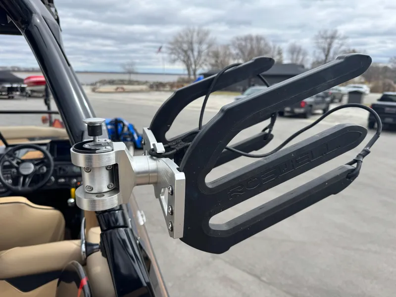 Slide: The Image of 2022 Moomba Makai boat with a wakeboard rack, parked near a lake. - 23