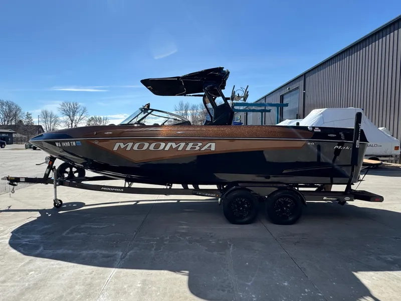 Slide: The Image of 2022 Moomba Makai boat on trailer, parked outdoors under clear blue sky. - 4