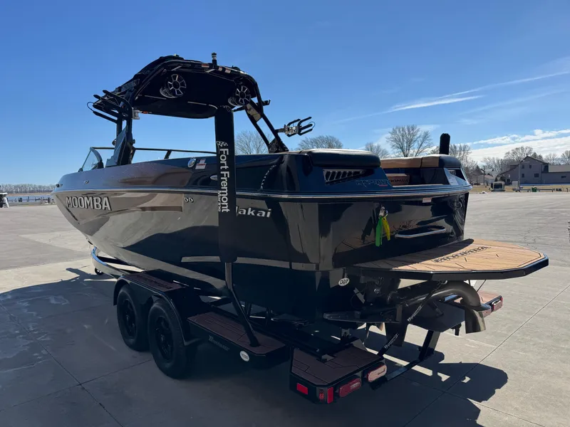 Slide: The Image of 2022 Moomba Makai boat on trailer, sleek black design, parked outdoors under clear sky. - 5