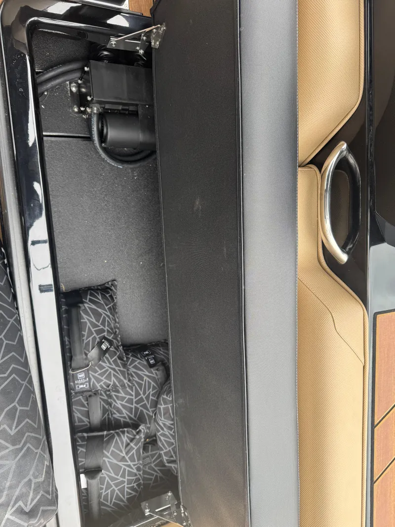 Slide: The Image of 2022 Moomba Makai boat interior storage compartment with black and tan seating. - 9