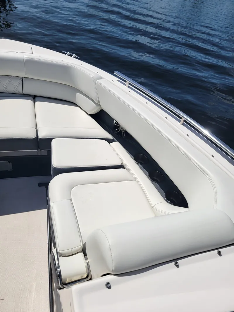 Slide: The Image of 2020 Regal 29 OBX boat with white cushioned seating on calm water. - 13