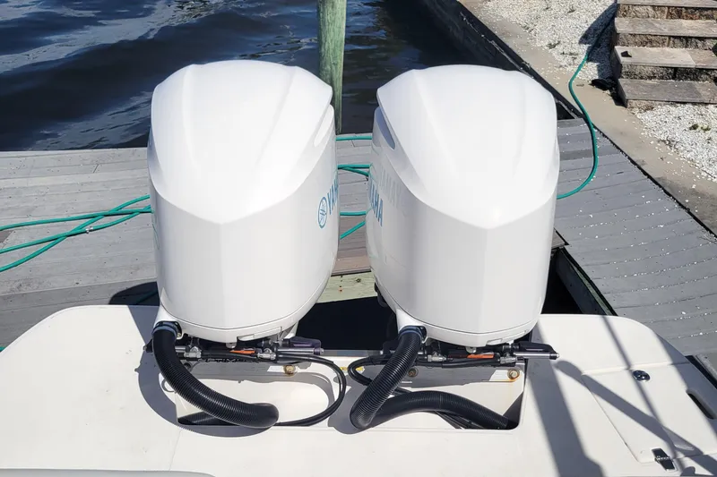 Slide: The Image of Twin outboard engines on a 2020 Regal 29 OBX boat docked by the water. - 14