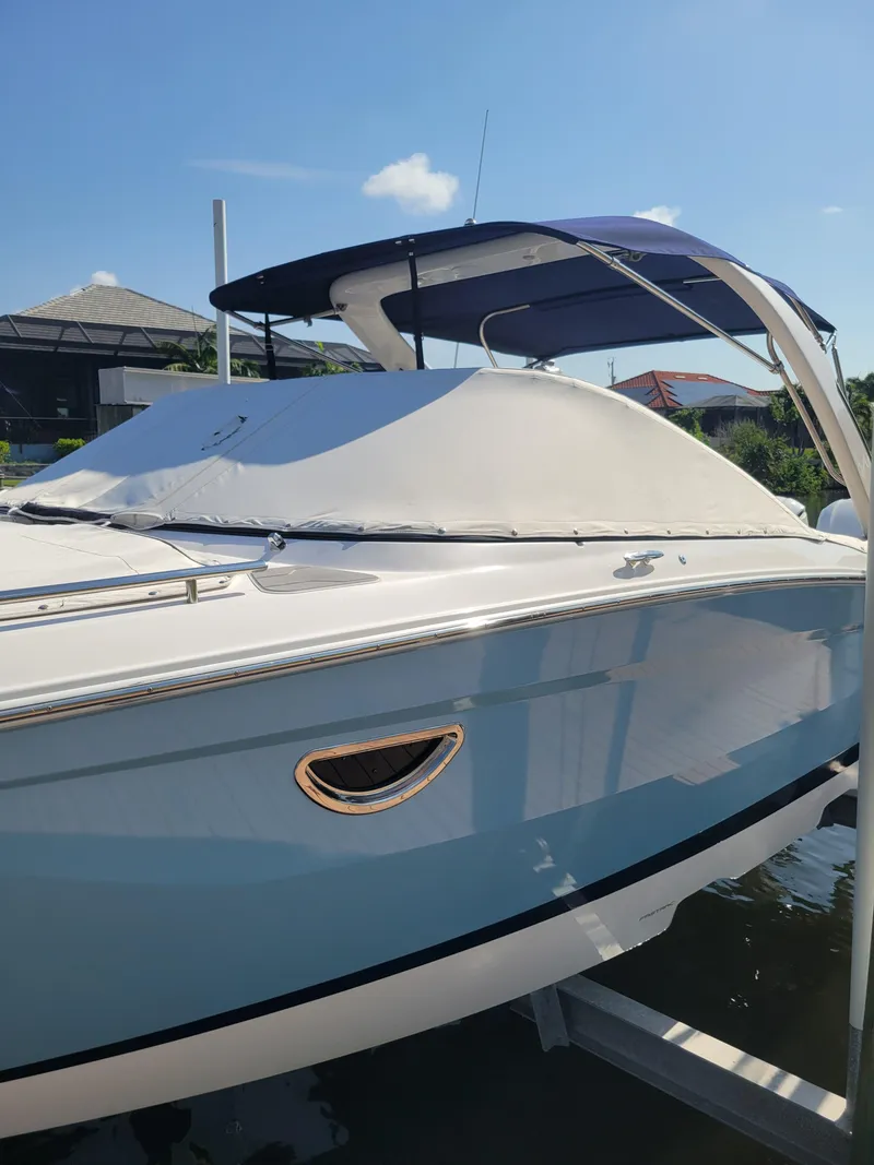 Slide: The Image of 2020 Regal 29 OBX boat with blue hull and covered deck, docked under sunny skies. - 3