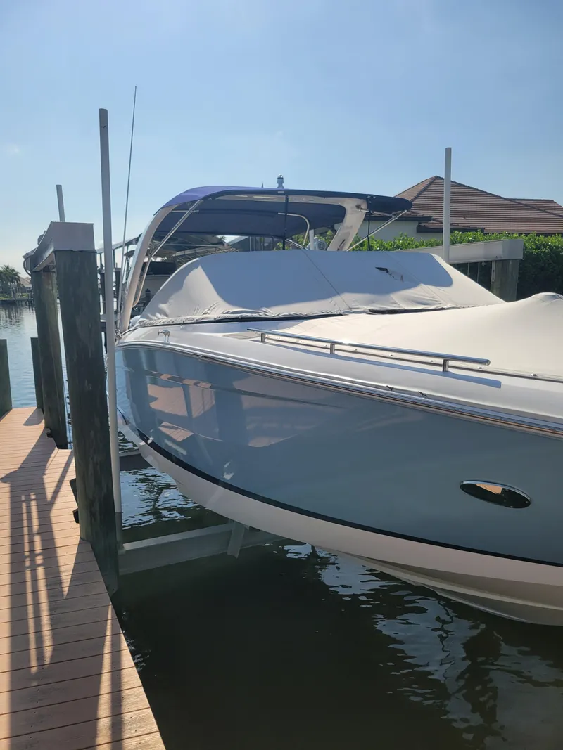 Slide: The Image of 2020 Regal 29 OBX boat docked, covered, and ready for a sunny day on the water. - 4