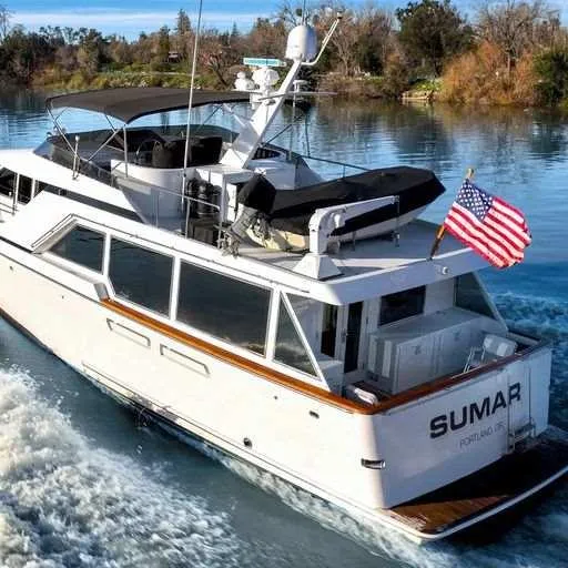 Slide: The Image of Vic Franck 65 Motor Yacht 1991 cruising on a serene river with American flag. - 11