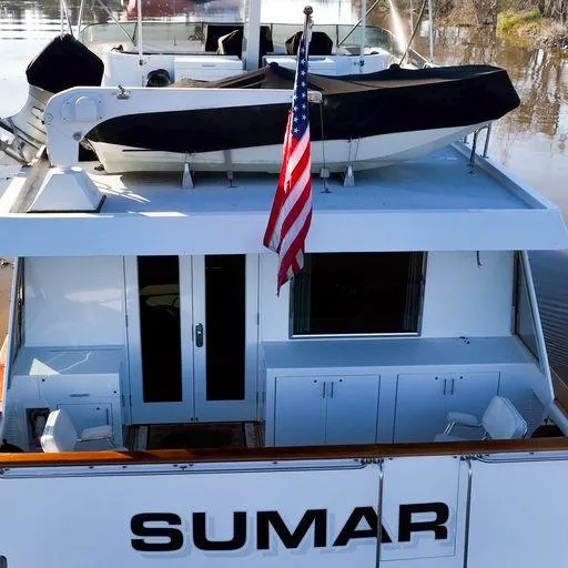 Slide: The Image of 1991 Vic Franck 65 Motor Yacht with American flag and tender on deck. - 12