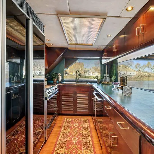 Slide: The Image of Luxurious kitchen interior of a 1991 Vic Franck 65 Motor Yacht with wood cabinetry. - 32