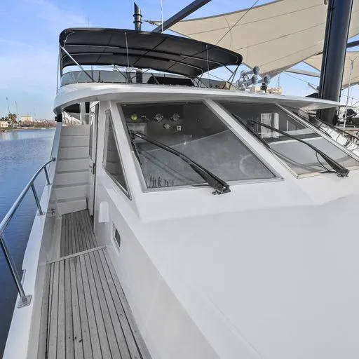 Slide: The Image of 1991 Vic Franck 65 Motor Yacht docked, showcasing sleek design and spacious deck. - 6