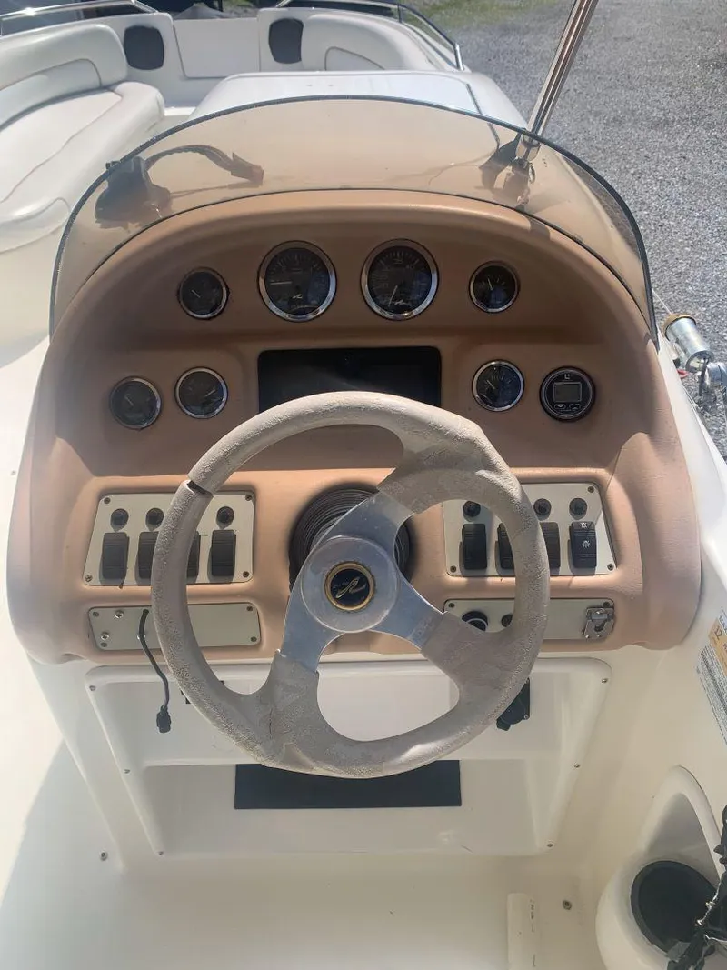 Slide: The Image of 1998 Sea Ray 240 Sundeck dashboard with steering wheel and control panel. - 11