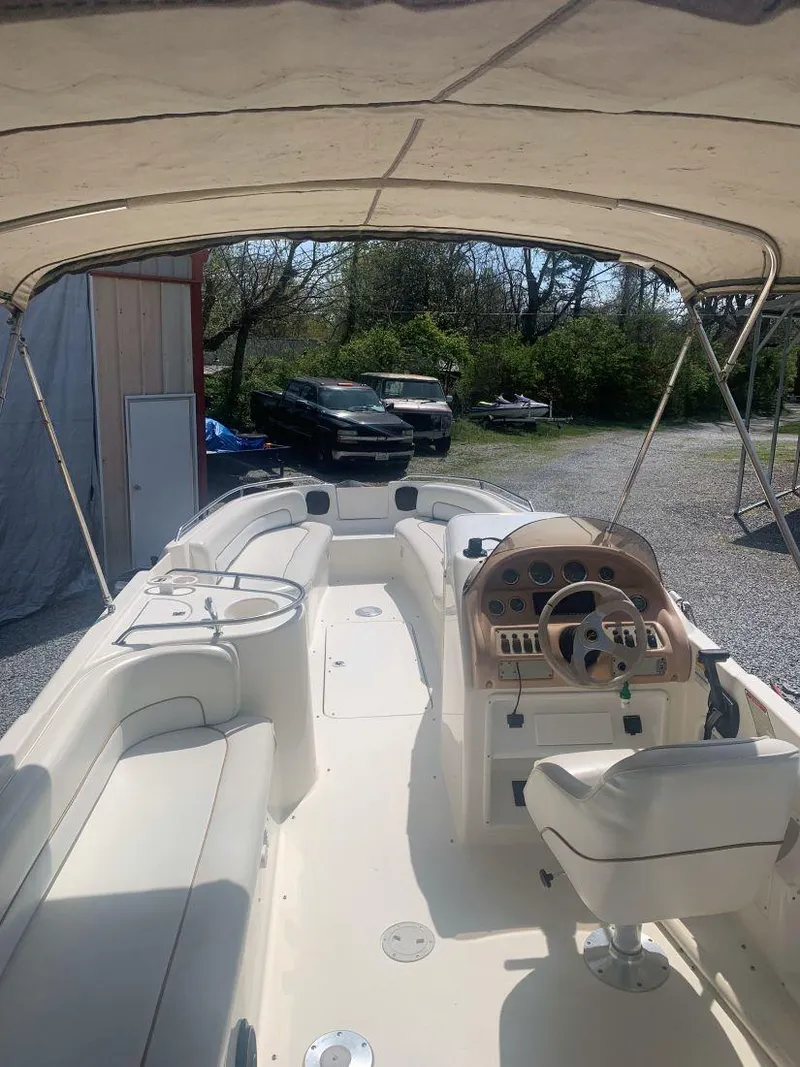 Slide: The Image of 1998 Sea Ray 240 Sundeck boat with canopy, parked outdoors. - 13