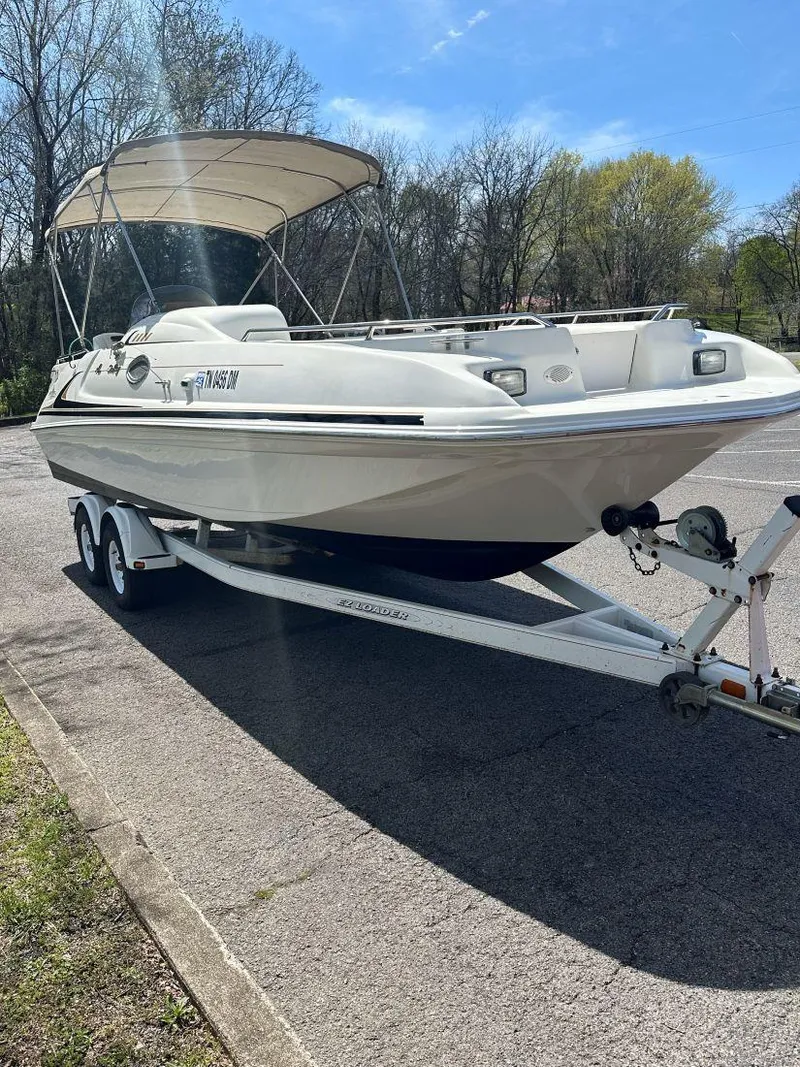 Slide: The Image of 1998 Sea Ray 240 Sundeck boat on trailer, parked outdoors under a clear sky. - 5