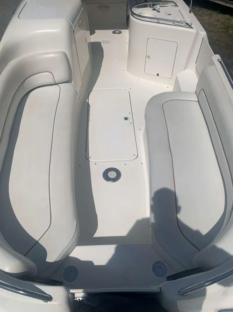 Slide: The Image of 1998 Sea Ray 240 Sundeck interior with white seating and storage compartments. - 8