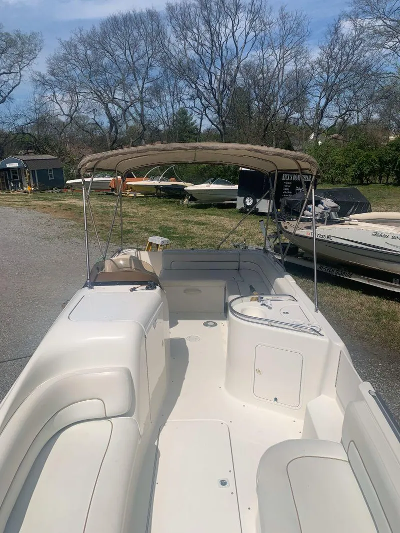 Slide: The Image of 1998 Sea Ray 240 Sundeck boat with canopy, parked outdoors on a sunny day. - 9