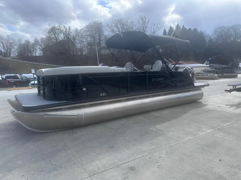 Slide: The Image of 2025 Sylvan Mirage X X5 CLZ DH pontoon boat on concrete surface under cloudy sky. - 3