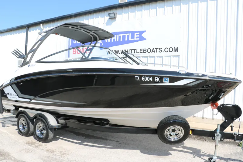 Slide: The Image of 2018 Yamaha Boats AR240 HO on trailer, black and white design, parked outside dealership. - 11