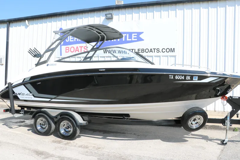 Slide: The Image of 2018 Yamaha Boats AR240 HO on trailer, black and white design, parked outside dealership. - 12
