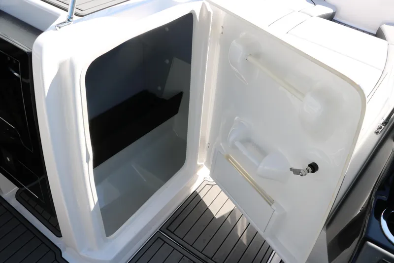 Slide: The Image of 2018 Yamaha Boats AR240 HO storage compartment with open door, showcasing interior space. - 19